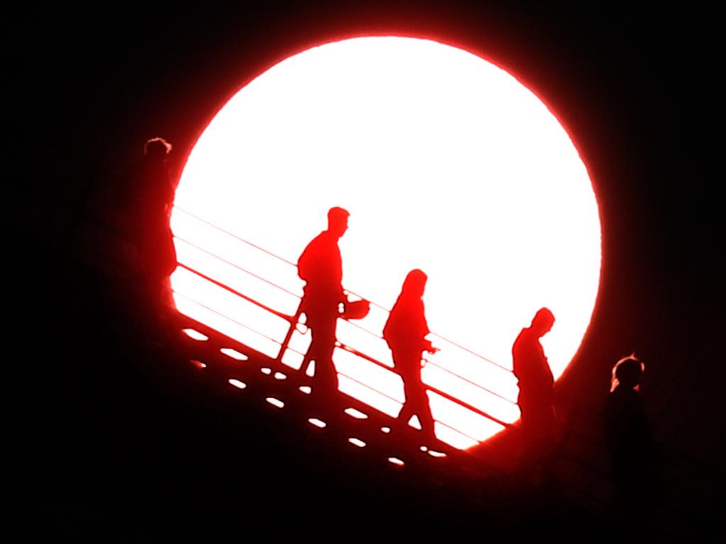 The Blood Moon rises as Storey Bridge climbers head back down. Picture: Annette Dew