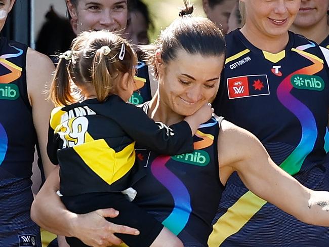 MELBOURNE, AUSTRALIA - OCTOBER 12: Kate Dempsey of the Tigers and daughter Pippa are seen during the 2024 AFLW Round 07 match between the Richmond Tigers and the Geelong Cats at Swinburne Centre on October 12, 2024 in Melbourne, Australia. (Photo by Michael Willson/AFL Photos via Getty Images)