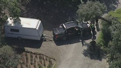 Police gather around a car and caravan at the scene of the tragedy. Picture: Channel 9