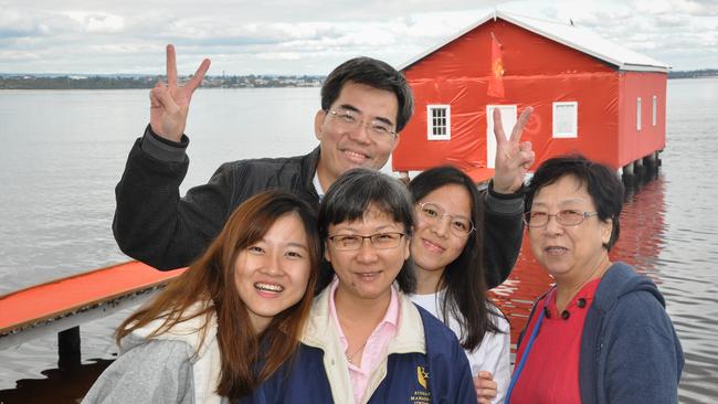 Singaporean Charlotte Chan (left) poses for a photograph with her family against the Crawley Edge Boatshed in Perth. Picture: AAP/Rebecca Le May