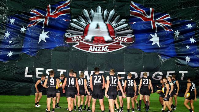 Port Adelaide run through the banner for the Anzac Day tribute in 2016. Picture: Sarah Reed