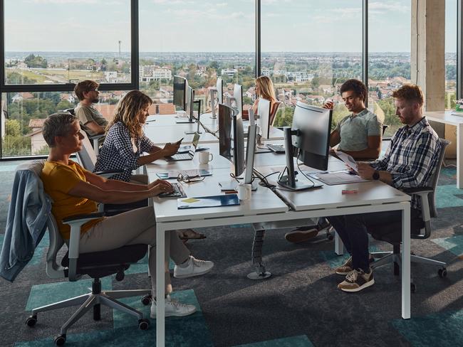 Large group of programmers working in a modern office of a software company. Copy space.