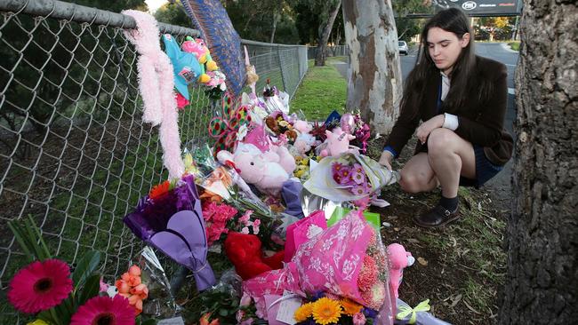 A mourner lays some flowers at the makeshift shrine. Picture: Andrew Tauber