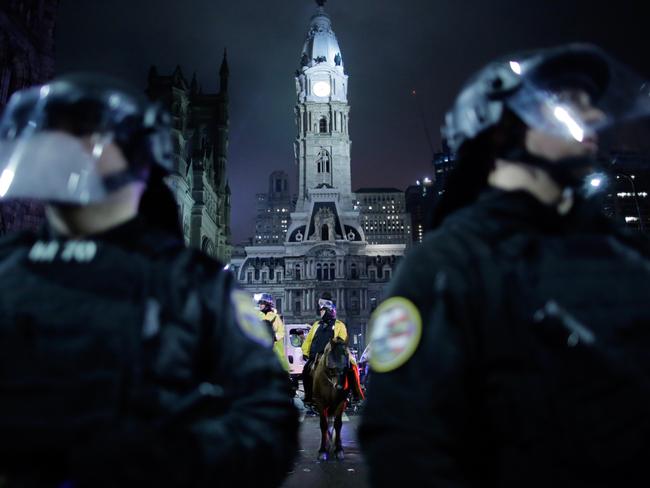 Police officers stand guard as Philadelphia Eagles fans celebrate.