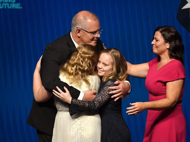 Australia's Prime Minister Scott Morrison (2nd L) hugs his daughters Abbey (L) and Lily (2nd R) with wife Jenny Morrison (R) after the Liberal Party's campaign launch in Melbourne on May 12, 2019. - Australia goes to the polls in a national election on May 18. (Photo by William WEST / AFP)