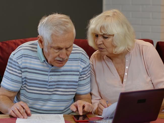 Worried senior retired couple checking calculating bills bank loan payment doing paperwork discuss unpaid debt taxes at home. Stressed old mature grandparents family upset about money problem concept; retirees generic