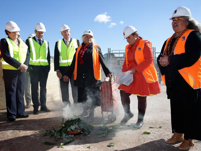 Susan Moylan-Coombs (right) leads a smoking ceremony at the site of the new Northern Beaches Hospital watched by former Health Minister Jillian Skinner, former Premier and Member for Manly, Mike Baird and Member for Wakehurst Brad Hazzard alongside Lois and Jessica Birk.