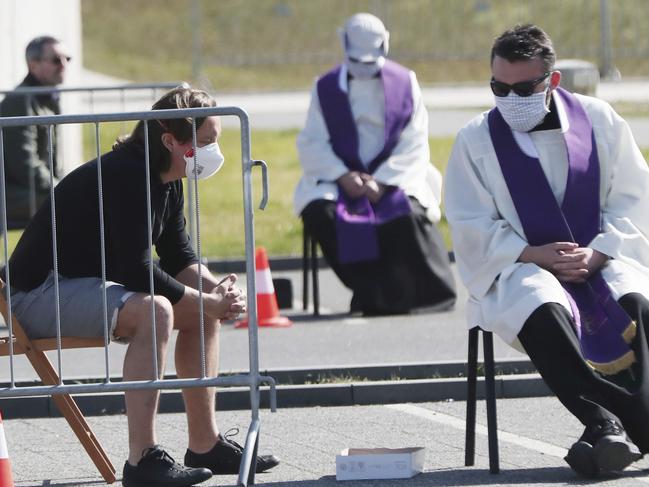 Priests take confession from the faithful on Good Friday as a precaution during the coronavirus pandemic in Warsaw, Poland. Picture: AP