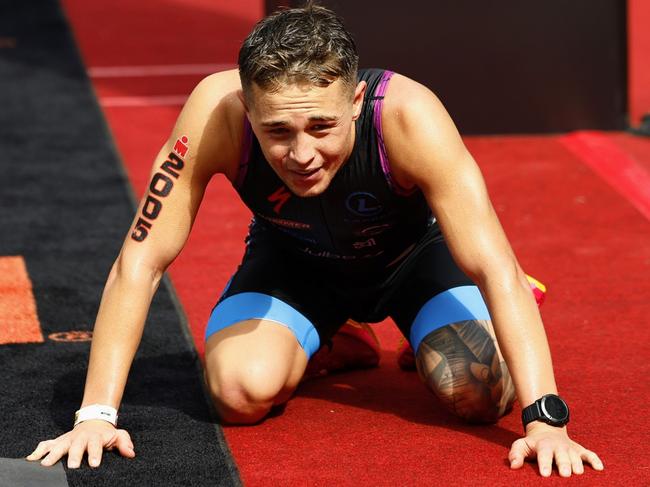 Former Cairns triathlete Daniel McDonnell falls onto his hands and knees after crossing the finish line to win the Ironman Cairns 70.3 race. Picture: Brendan Radke