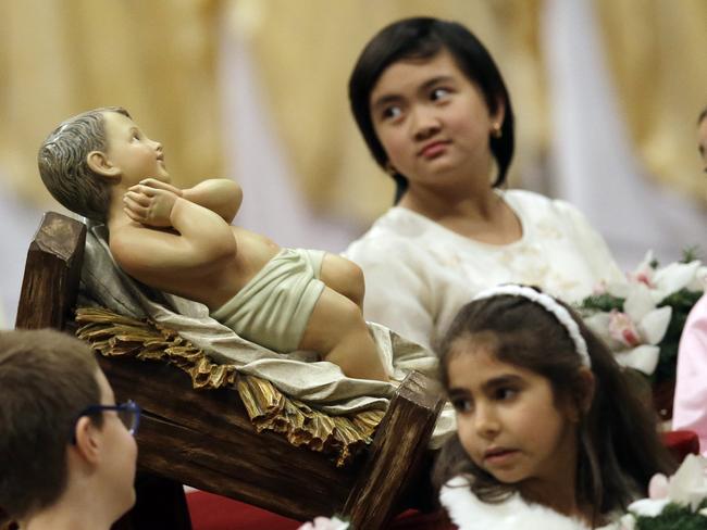 Children look at a statue of Baby Jesus during the Christmas Eve Mass celebrated by Pope Francis in St. Peter's Basilica at the Vatican. Picture: AP/Gregorio Borgia