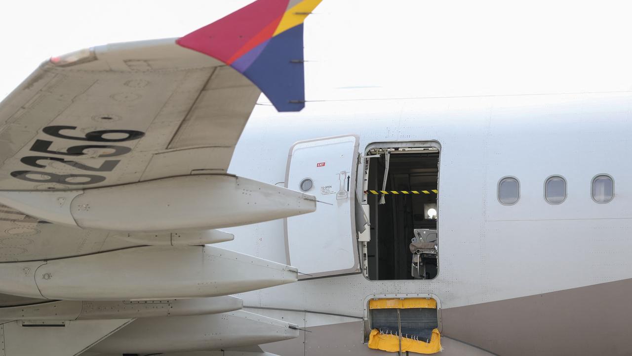 An opened door of an Asiana Airlines plane is seen at Daegu International Airport after it was manually opened by a passenger just 200 metres above the ground before landing. (Photo by YONHAP / AFP)