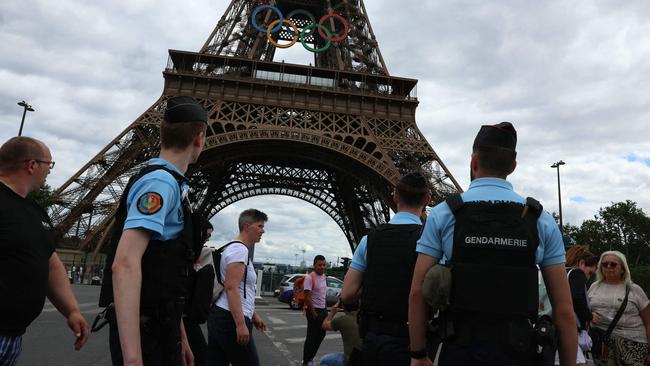 Gendarmes patrol The Eiffel Tower adorned with the Olympic rings Picture: AFP