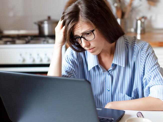 CORONAVIRUS: Picture: istock Upset woman working from home office. Worry freelancer using laptop and the Internet. Workplace in cozy kitchen. Concept of female business and career, housekeeping, stress. Lifestyle moment.