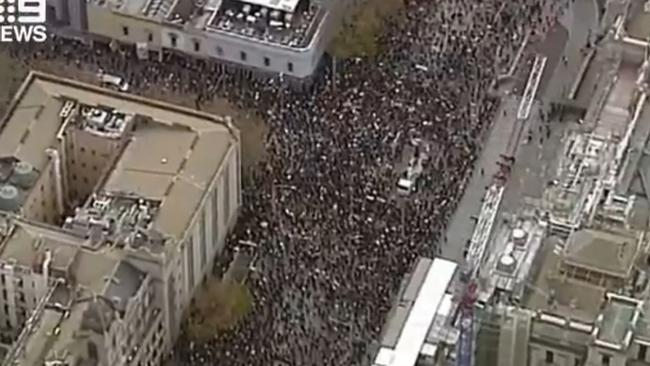 A screen grab taken from Nine News shows the crowds pouring down Bourke St. Picture: Channel 9