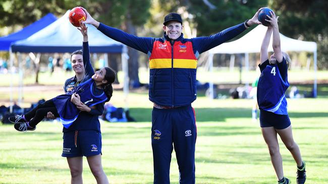 Adelaide’s Sam Jacobs, centre, with Crows AFLW player Ebony Marinoff and Joselin, 9, of Brompton Primary School and Taylor, 10, at St Dominics Oval last week. Picture: Mark Brake