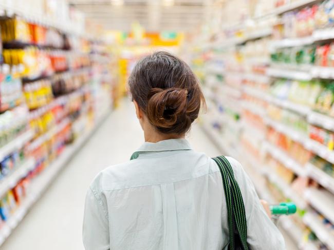 ESCAPE: Woman pushing a shopping cart in the supermarket, focus on woman. Picture: Istock