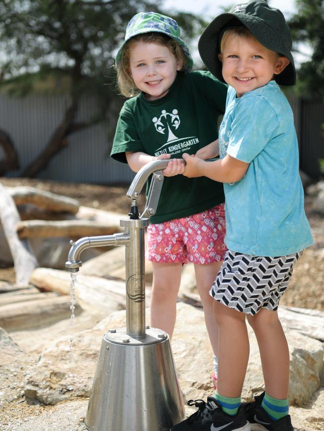 Rachael and Blair try out a water pump at the new Netley nature playground. Picture: AAP/Morgan Sette