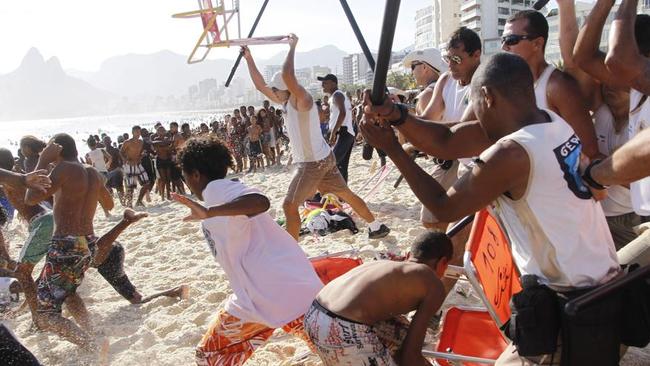 In this Nov. 20, 2013 photo, municipal guards chase a gang of thieves that robbed bags and wallets from beachgoers on Arpoador beach in Rio de Janeiro, Brazil. Gang raids known as “arrastoes,” or “big drags” in Portuguese, spread alarm through a city gearing up to host soccer’s World Cup in just over six months and the Summer Olympics in 2016. (AP Photo/Marcelo Carnaval, Agencia o Globo)