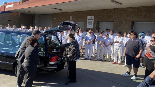 Rosemary Milisits touches her husband’s coffin as his hearse leaves his bakery one final time. Picture: Kathryn Birmingham