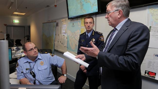 Radio dispatch operator Senior Sergeant Rob Cooke (left) speaks with Police Commissioner Darren Hine and Police Minister, Rene Hidding