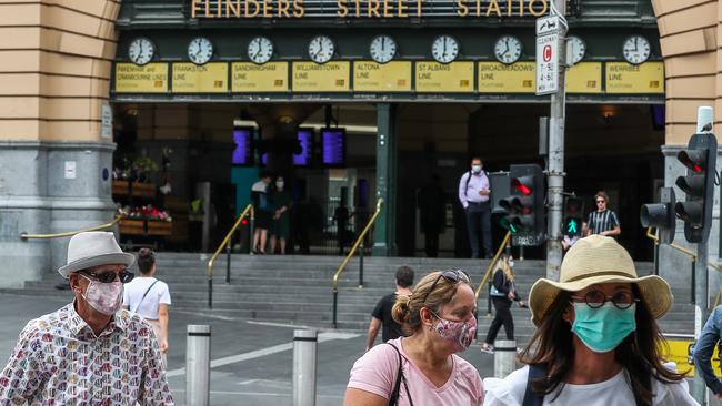 People wearing masks are seen walking past Flinders Street Station on February 04, 2021 in Melbourne, Australia.