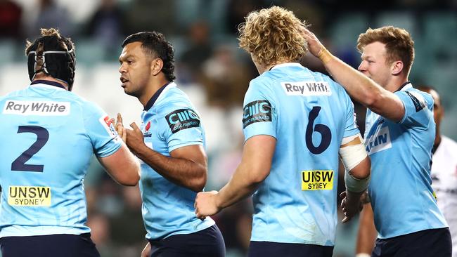 Waratahs players celebrate a try to Kurtley Beale (second left).