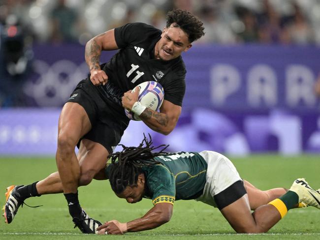 New Zealand's Moses Leo (L) is tackled by South Africa's Rosko Specman (R) during the men's pool A rugby sevens match between New Zealand and South Africa during the Paris 2024 Olympic Games at the Stade de France in Saint-Denis on July 24, 2024. (Photo by CARL DE SOUZA / AFP)