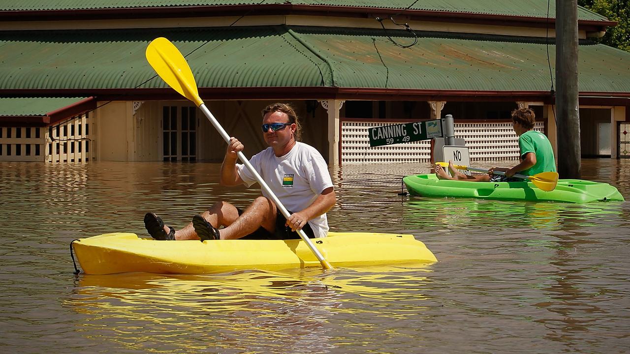 North Ipswich residents Martin Lowe (l) and his son Kurt (r) inspect the flooded Pelican &amp; Canning Street's in North Ipswich , Wednesday 12, 2011.