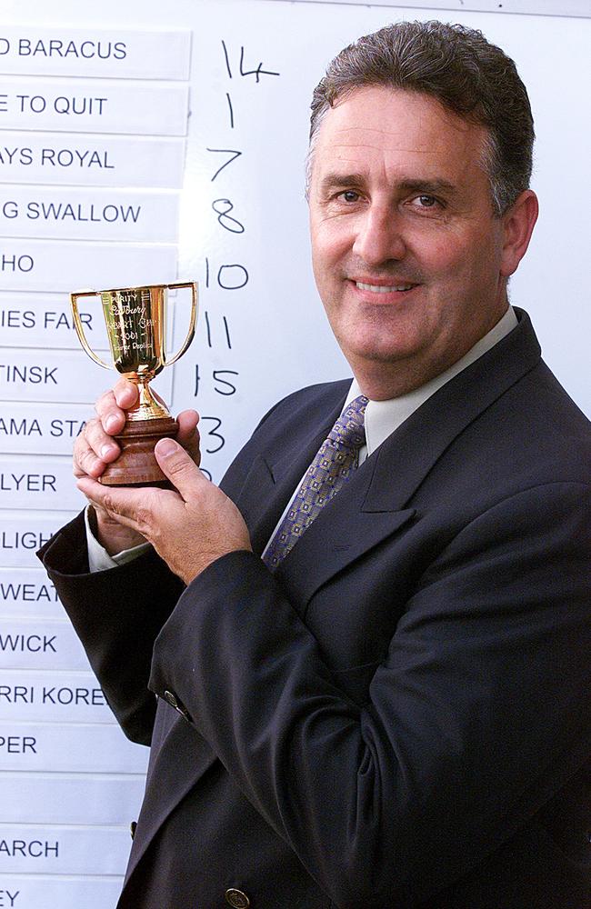 Race caller Colin McNiff holding up a mini cup at Hobart Cup in 2001.