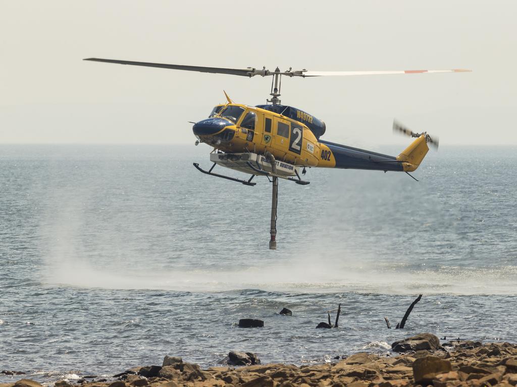 A water-bombing helicopter fills up at Great Lake. Picture: Heath Holden/Getty