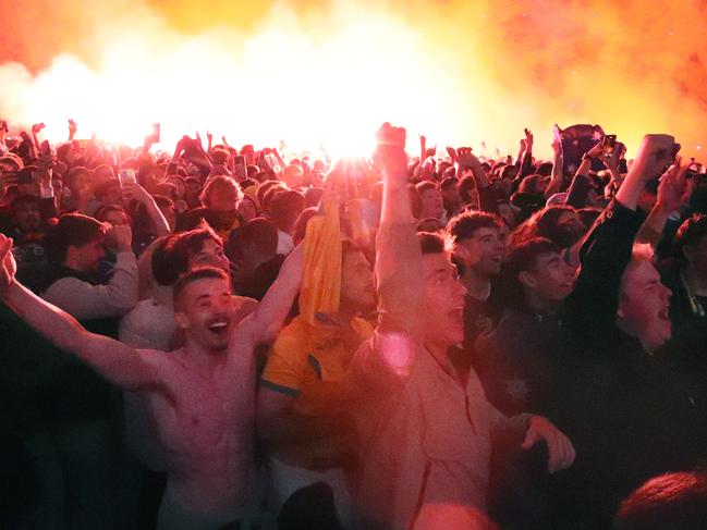 Federation Square was bathed in red flare mist as fans celebrated the remarkable win. Picture: NCA NewsWire / David Crosling