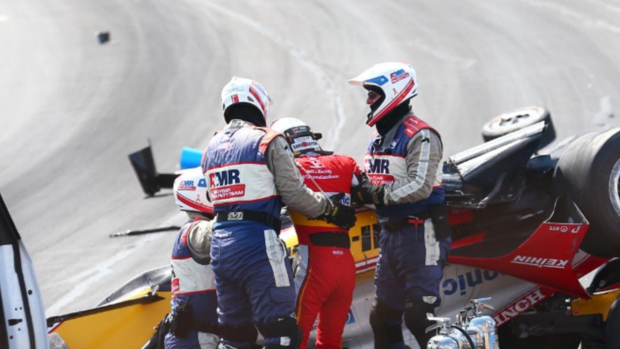 Takuma Sato is helped from his wrecked car.