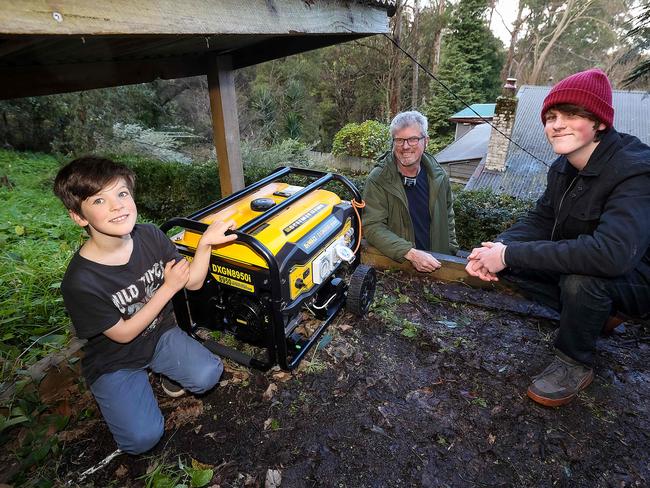 ADF , CFA and SES crews deliver a generator to Ferny Creek resident Steve Hermans and his sons Charlie 8yrs and Josh 15yrs.Many houses were left without power in last weeks storms. Picture : Ian Currie