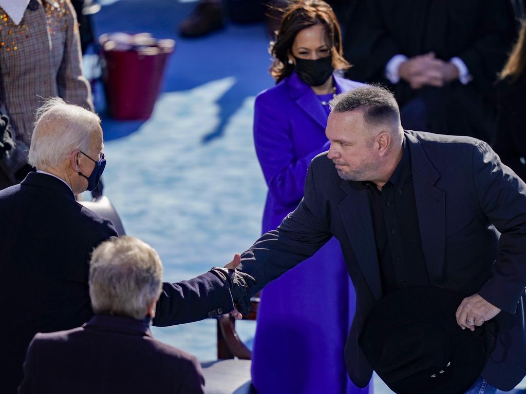 Singer Garth Brooks shakes hands with President Joe Biden during the inauguration ceremony on the West Front of the US Capitol as Kamala Harris looks on. Picture: Getty Images