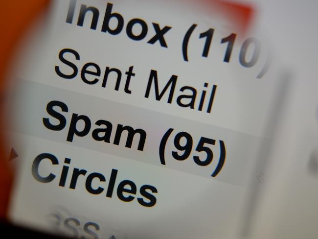 Magnifying glass showing a spam folder in the mailbox on the monitor screen.