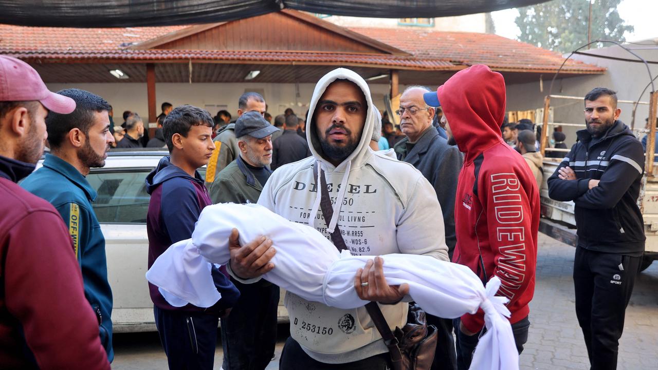 A man carries the body of a child killed during an Israeli strike, at Al-Ahli Arab hospital in Gaza City. Picture: Omar Al-Qattaa/AFP