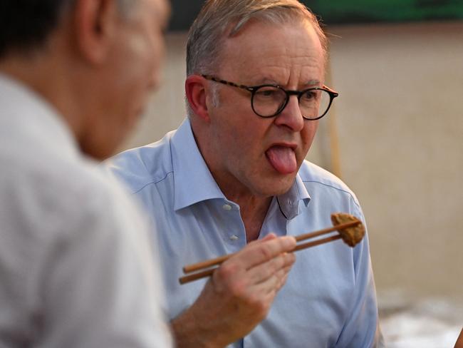 Mr Albanese trying a fish cake with chopsticks. Picture: Nhac Nguyen