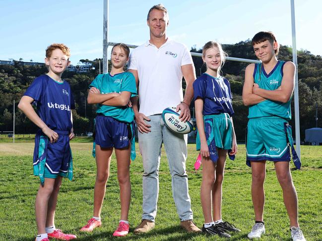 WEEKEND TELEGRAPH. JULY 19, 2024.Pictured in Newport today is Mark Gasnier with kids Mitch Lukeman 12, Havana Gasnier 11, Amber Reynolds 10 and Bowie Fitzgerald 13. Mark is signing a deal with Rugby Australia to ensure his Tri Tag non-contact version of rugby is the official program used in schools throughout the country. Picture: Tim Hunter.