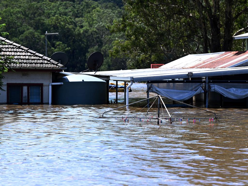 A clothesline and house are seen partially submerged under floodwater at Sackville North, NSW. Picture: NCA NewsWire/Bianca De Marchi