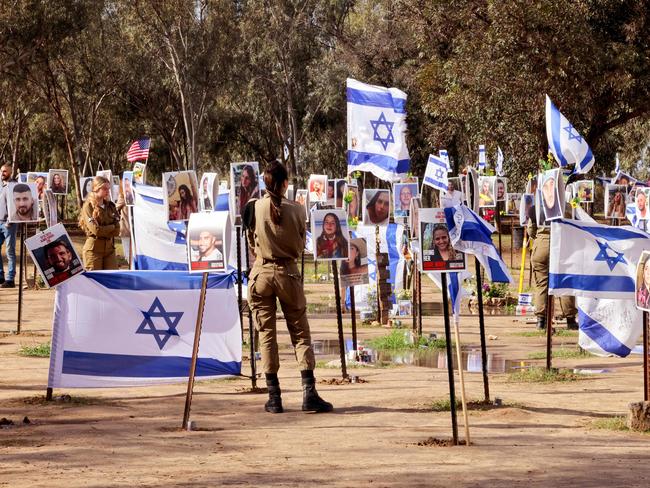 Israeli soldiers walk among portraits of people taken captive or killed by Hamas militants during the Supernova music festival. Picture: Jack Guez / AFP