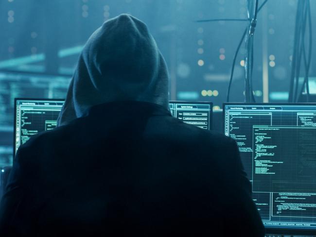 Dangerous Hooded Hacker Breaks into Government Data Servers and Infects Their System with a Virus. His Hideout Place has Dark Atmosphere, Multiple Displays, Cables Everywhere.