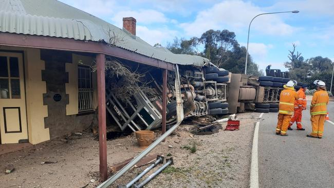 The cattle truck rolled on to a house, trapping the driver.