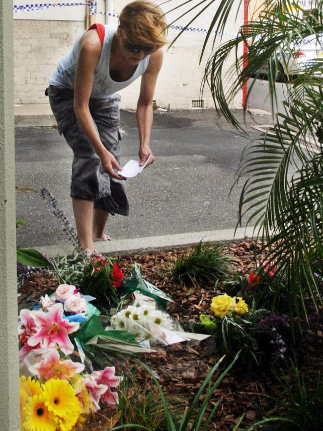 A woman lays flowers at the scene of the murder of store owner Frank Newbery, 87, in Union St Newcastle.