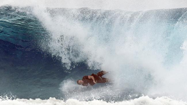 A surfer falls from his board at Snapper Rocks on the Gold Coast, Thursday February 21, 2019. Huge swells and high tides are set to pummelling southeast Queensland beaches over the coming days as Cyclone Oma tracks towards the Queensland coast. (AAP Image/Dave Hunt)