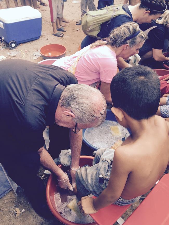 Bill Crews washing children’s feet in Poipet.