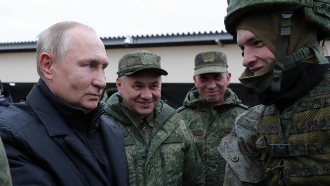 Vladimir Putin and Defence Minister Sergei Shoigu (C) meet soldiers during a visit at a military training centre of the Western Military District for mobilised reservists. Picture: AFP.