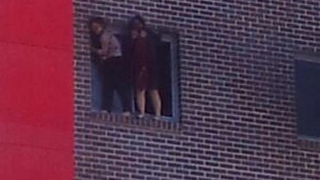 Yinuo “Ginger” Jiang and Pingkang “Connie” Zhang cling to the window ledge at the height of the 2012 fire.