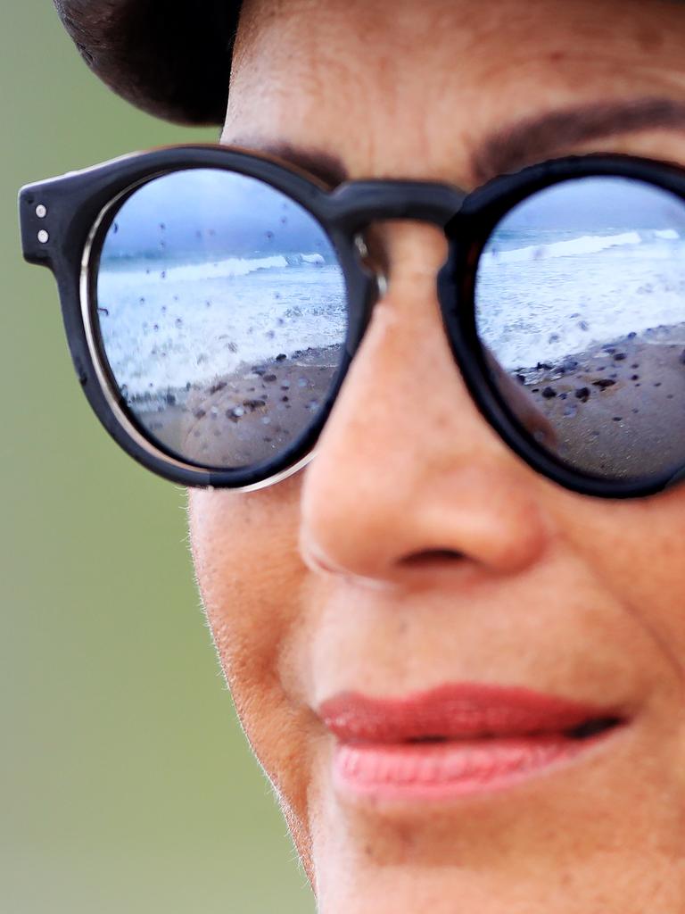 Cassandra McCarthy from Mermaid Beach watches surfers at Burleigh Beach as wet weather descended over the Gold Coast. Photo: Scott PowickNEWSCORP