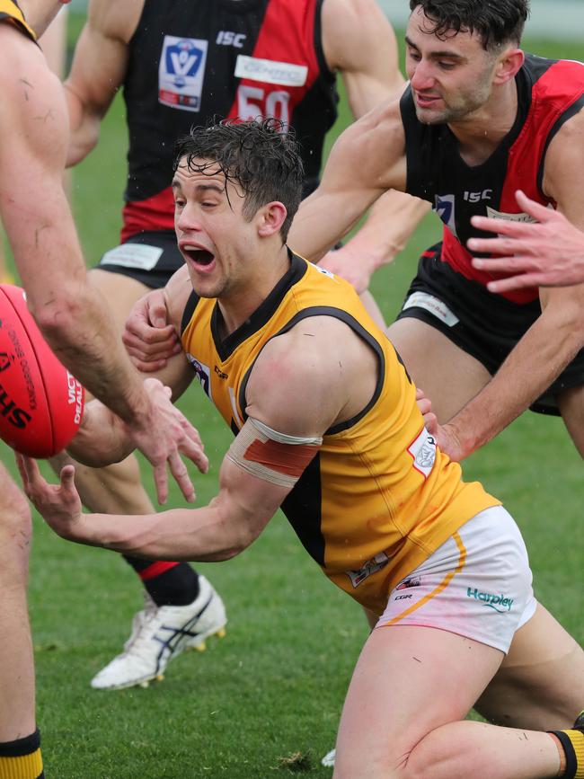 Tom Gribble fires out a handball under pressure against Essendon. Picture: Michael Klein.