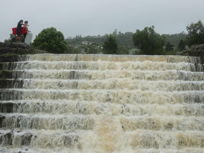 Wet weather continues to impact the Gold Coast. The floodwaters cascade from Flooded Gum Park at Pacific Pines. Picture Glenn Hampson